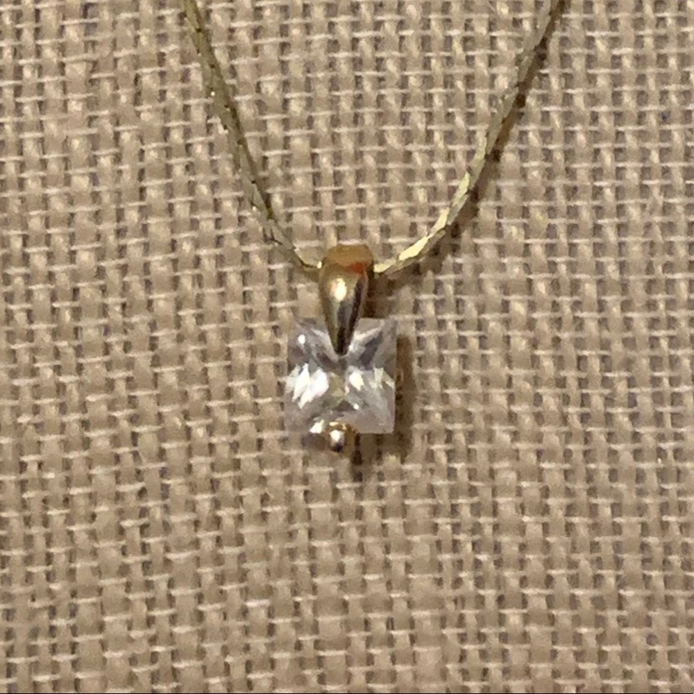 Gold necklace and diamond stud pendant.